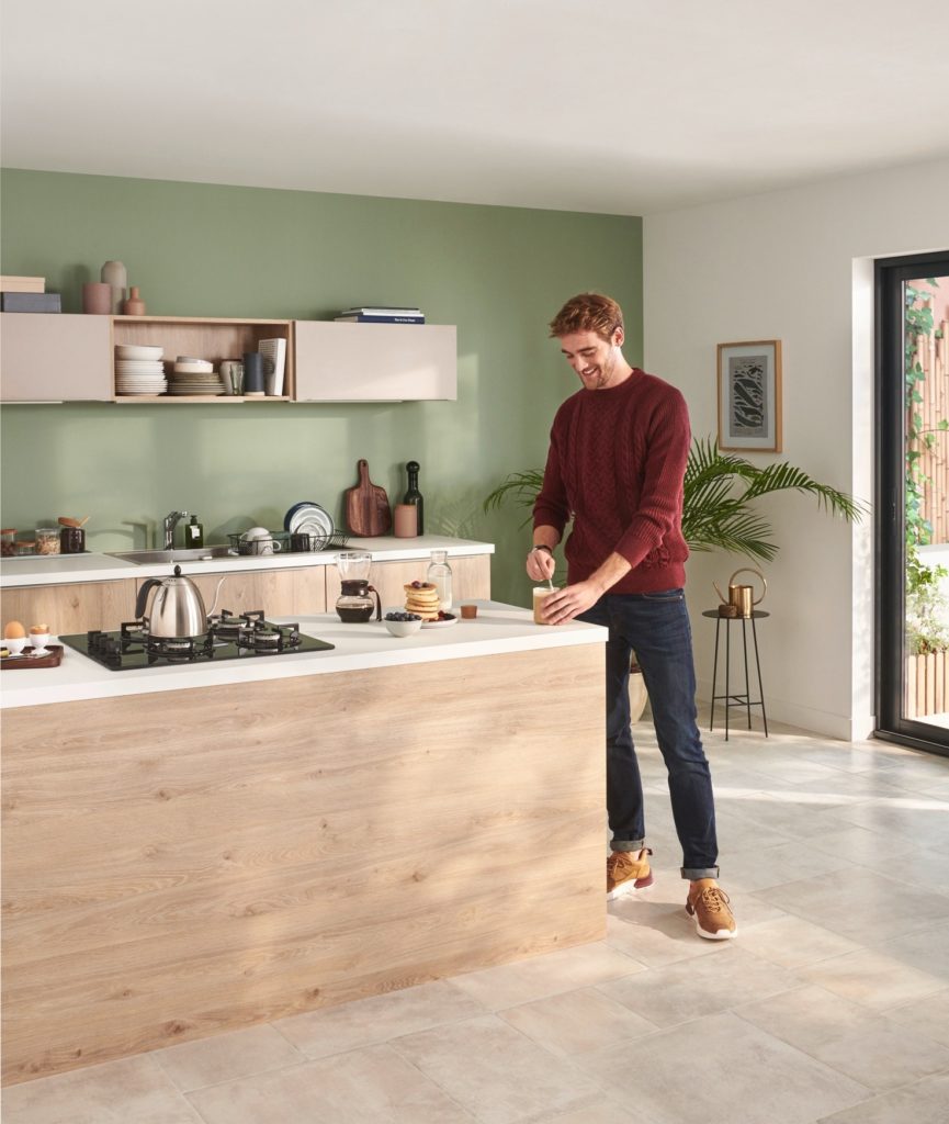 Plan de travail dans une cuisine moderne en îlot avec homme qui cuisine