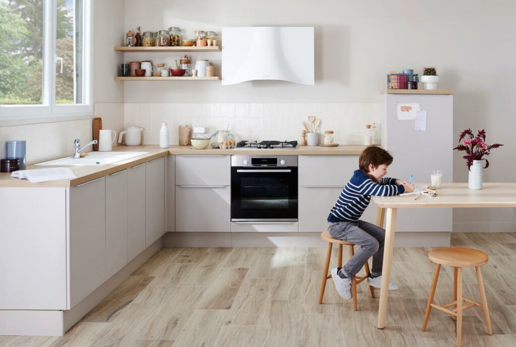 Enfant faisant ses devoirs sur une table dans une cuisine ouverte